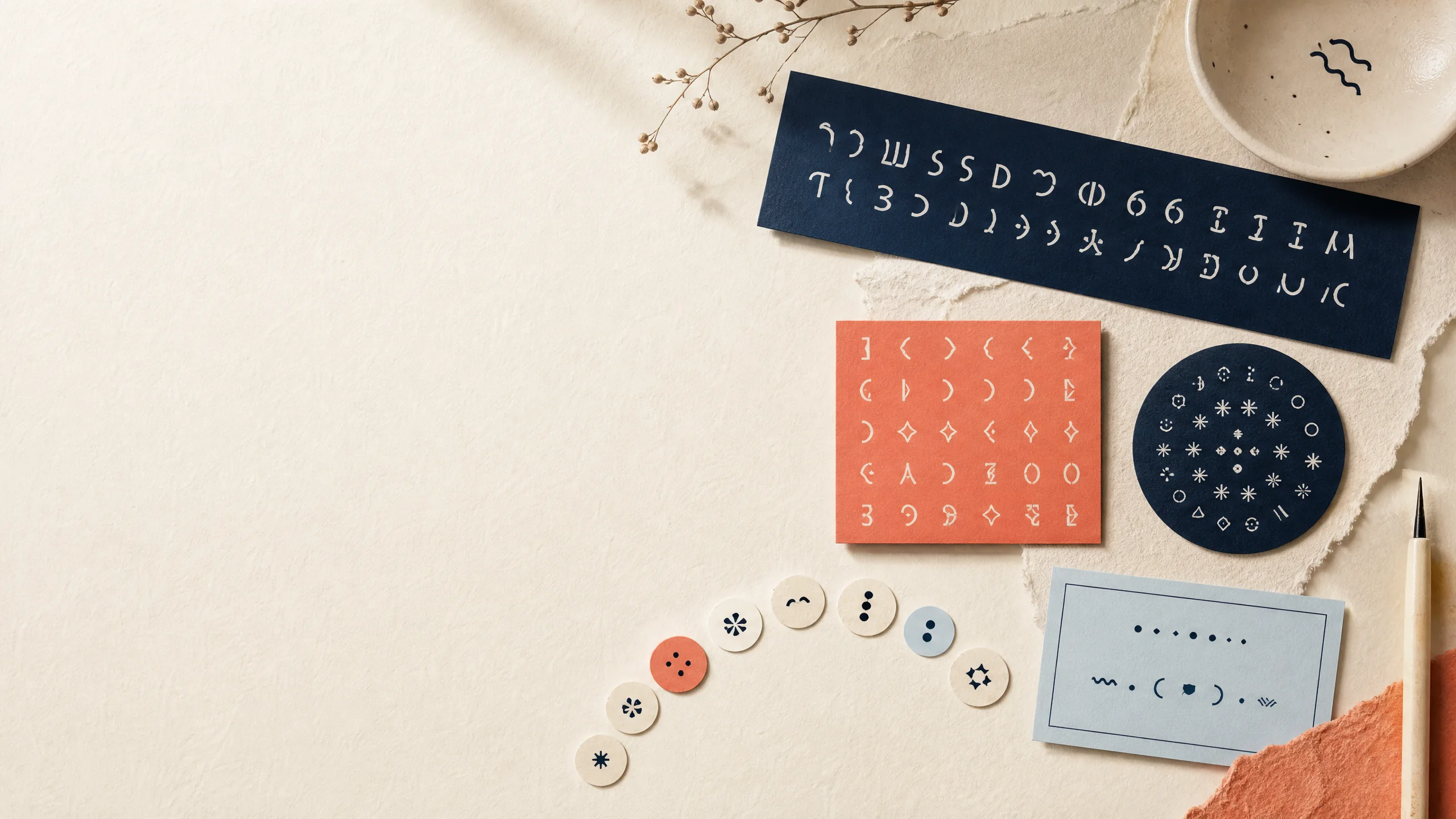 Typographic specimen cards, a flipped text strip, and decorative punctuation on an ivory desk